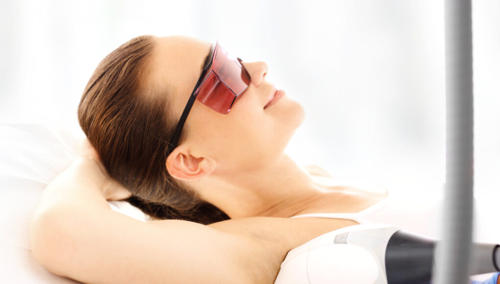 Salon kosmetyczny, depilacja laserem. Kobieta na zabiegu depilacji laserowej
